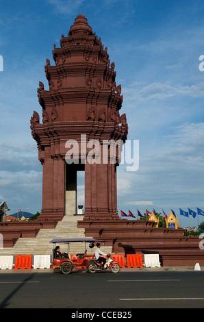 Unabhängigkeitsdenkmal & Tuk Tuk tagsüber, ungewöhnlicher Verkehr & Transport auf einem Kreisverkehr in Phnom Penh, Kambodscha. Kredit: Kraig lieb Stockfoto