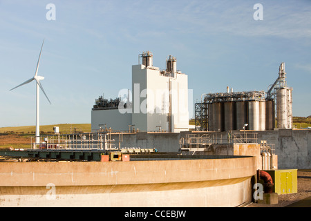 Das Kodak-Werk in Workington Cumbria, mit einer Windkraftanlage, die dazu beitragen, schalten Sie die Anlage mit einer Kläranlage im Vordergrund. Stockfoto