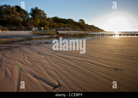 Angelboot/Fischerboot auf dem Strand in Rewal. Sonnenuntergang über der Ostsee. Stockfoto