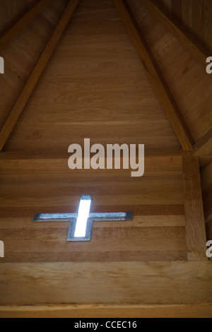 Blickte zu einem Holzdach eine kleine Kapelle.  Eine kreuzförmige Fenster können im Licht. Stockfoto