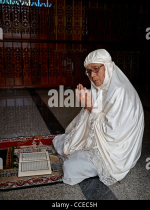 90 Jahre alte muslimische Thai-Frau betet und trägt eine weiße traditionelle Burka Stockfoto