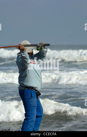 Ein Enthusiast Winkel für Ernst große Fische in der rauen Brandung vor der berüchtigten Schiffswrack verstreut Skelett Küste von Namibia. Stockfoto