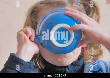 Mädchen trinken aus der Schüssel Stockfoto