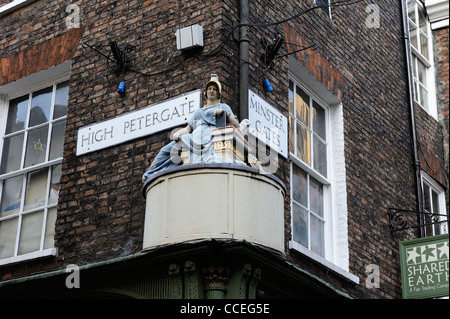 Statue der Minerva Goddess Weisheit oberhalb von Geschäften an der Ecke der hohen Petergate und Münster Tore York England uk Stockfoto