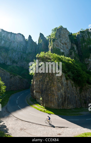 Ein einsamer Radfahrer klettert an einem sonnigen Sommermorgen eine verkehrsfreie Straße durch die dramatische Cheddar-Schlucht. Stockfoto