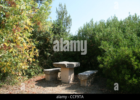 Steinbank und Tisch im Garten in Landschaft Stockfoto