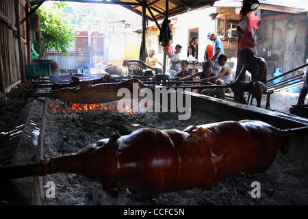 31. Dezember 2010 - Cotabato, Philippinen - Filipino Arbeiter in einer Fleischerei in den südlichen Philippinen Cotabato vorzubereiten und gebratene Schweine, ein beliebtes Gericht für Feiertage und besondere Anlässe. Die Schweine werden auf Spieße über Kohlen geröstet. (Kredit-Bild: © Jeoffrey Maitem/ZUMApress.com) Stockfoto