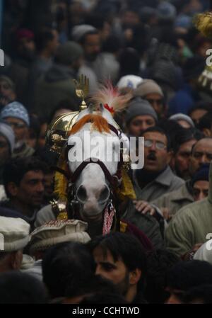 16. Dezember 2010 - Sommer Kaschmir, Srinagar, Indien - ein Kashmiri muslimischen schiitischen muslimischen Trauergäste nehmen Sie eine Prozession zusammen mit einem geschmückten Pferd während einer Muharram-Prozession am Vorabend des Aschura-Festival in Srinagar, Hauptstadt des indischen Teil Kaschmirs. Das Pferd steht symbolisch für das Pferd des Imam Hussein. Stockfoto