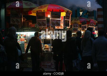 23. November 2010 entspringt ein Mannloch im Bau in der Nähe einer Reihe von Menschen warten auf Essen aus einem Hotdog-Stand beleuchtet mit Lichtern auf einer dunklen Ecke der Fifth Avenue in Manhattan - New York, New York, USA - Rauch. (Bild Kredit: Mariela Lombard/ZUMApress.com ©) Stockfoto