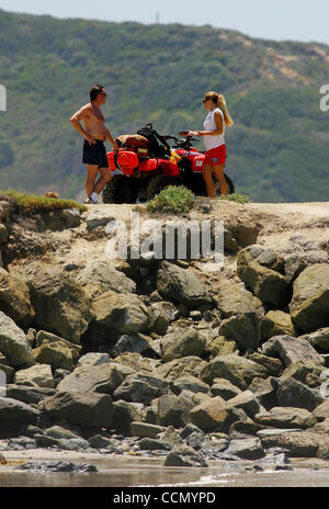 17. Juli 2004; Salt Creek, Kalifornien, USA; Rettungsschwimmer stehen neben ihrem Quadbike, ATV oder all-Terrain-Fahrzeug, im Gespräch mit einem Strand Goer. Strand Rettungsschwimmer arbeiten entlang der kalifornischen Küste von Santa Cruz nach San Diego und auf einige der wichtigsten California Binnenseen. Sie sehen von einer Station oder Turm für su Stockfoto