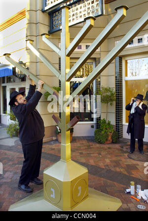 Rabbi Yaakov Kagan wirft Bestandteil der größte Memorah von Osten Buchten Freitagmorgen 3. Dezember 2004, als Freund, den Meshvliam Hirsch ein Bild von ihm, am Braodway Plaza in Walnut Creek, Kalifornien nimmt Während einige Malls und große Einzelhändler sind in jüdischen Chanukias Dilettantismus oder Kwanza Kerzen, den Großteil der nicht-christlichen Stockfoto