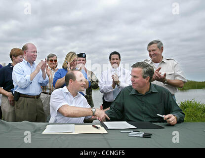 BOYNTON BEACH - nach der Unterzeichnung eines Dokuments, die gehen voraus, beschleunigen die die Wiederherstellung des Everglades, Gouverneur Jeb Bush schüttelt Hände mit Nick Gutierrez, Vorsitzender des Direktoriums der South Florida Water Management District.  Den Plan zur Beschleunigung der größte Umwelt mitteilen zu Stockfoto