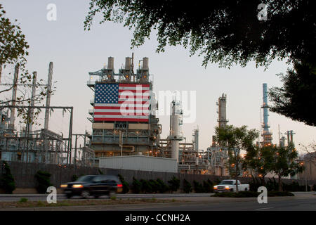 18. Oktober 2004; Long Beach, Kalifornien, USA; Conoco Philips Ölraffinerie bei Carson nr Long Beach Kalifornien mit großen Stars und Stripes USA-Flagge hängen neben den riesigen Chimmney Schornsteinen. Die Raffinerie verfügt Sicherheitszaun mit Stacheldraht Stacheldraht um ihn herum. Sicherheit wurde bei Refinerys über erhöht. Stockfoto