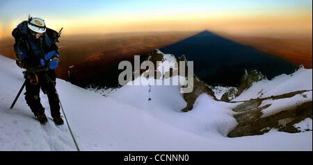 17. Juni 2004 - Woodburn, Oregon, USA - BRIAN BARKER prüft seine Uhr zu sehen, wenn das leitende Team den Mt. Hood Gipfel erreichen könnte. Hinter ihm wirft der Sonnenaufgang hinter den Bergen kommen seinen Schatten auf das darunter liegende Tal.  (Kredit-Bild: © l.e. Baskow/ZUMA Press) Stockfoto