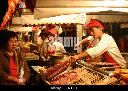 14. Juni 2004 - Peking, China - ein Nachtmarkt in Peking, wo Händler Nudeln verkaufen, gebratene Ziege Hoden, gebratene Seidenraupe, gebratener Tintenfisch, Fleisch, getrocknete Insekten, getrocknete Skorpione, Zikaden und andere Insekten. (Kredit-Bild: © Zack Baddorf/ZUMA Press) Stockfoto