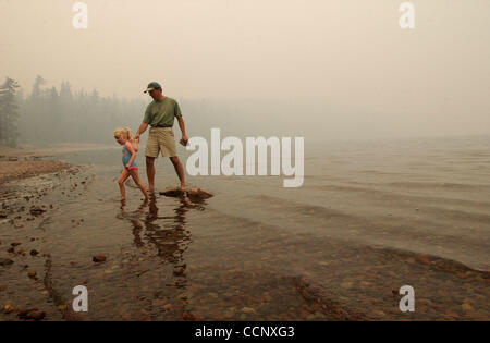 15. August 2003; Glacier National Park, Montana, USA; Rauch von Robert Fire und anderen nahe gelegenen Waldbrände verdeckt die Sicht wie Touristen waten in Lake McDonald in Glacier Nationalpark. Das Feuer Saison 2003 ist außergewöhnlich in Montana tätig. Obligatorische Credit: Foto von Robin Loznak/ZUMA Press / Stockfoto