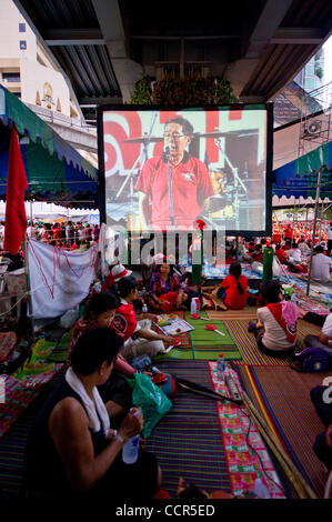 Red Shirts, auch bekannt als Vereinigte Front für Demokratie gegen Diktatur (UDD), Anhänger des gestürzten Ministerpräsidenten Thaksin Shinawatra anhören ihres Führers Rede auf Leinwand während der anhaltenden Proteste gegen die Regierung auf Ratchaprasong anspruchsvolle thailändische Premierminister Abhisit Vejjajiva aufzulösen Stockfoto