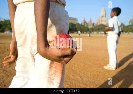 28. April 2010, Mumbai, Indien - bereitet ein junger Cricketspieler Schüssel einen Ball während des Trainings auf den weitläufigen Azad Maidan Cricket Grounds in South Mumbai, eines der größten und beliebtesten in der Stadt. Während des Kampfes für die Unabhängigkeit Indiens, Führer wie Mahatma Gandhi und Lal Bahadur S Stockfoto