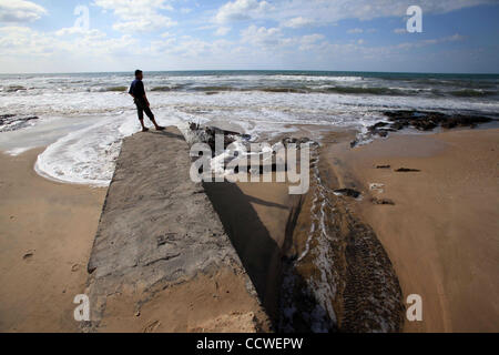 22. März 2010 - Strand von Gaza, Gaza-Streifen - steht ein palästinensischer Mann auf einem Abwasser-Steckdose am Strand im Zentrum des Gazastreifens gießen. Im Gaza-Streifen, wo die 1,5 Millionen Menschen, mehr als 40 private Kläranlagen und mindestens 20.000 home Reinigung Filter Leben dienen zur sicheren trinken wate Stockfoto