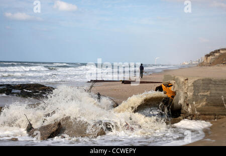 22. März 2010 - Strand von Gaza, Gaza-Streifen - steht ein palästinensischer Mann auf einem Abwasser-Steckdose am Strand im Zentrum des Gazastreifens gießen. Im Gaza-Streifen, wo die 1,5 Millionen Menschen, mehr als 40 private Kläranlagen und mindestens 20.000 home Reinigung Filter Leben dienen zur sicheren trinken wate Stockfoto