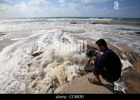 22. März 2010 - Strand von Gaza, Gaza-Streifen - steht ein palästinensischer Mann auf einem Abwasser-Steckdose am Strand im Zentrum des Gazastreifens gießen. Im Gaza-Streifen, wo die 1,5 Millionen Menschen, mehr als 40 private Kläranlagen und mindestens 20.000 home Reinigung Filter Leben dienen zur sicheren trinken wate Stockfoto