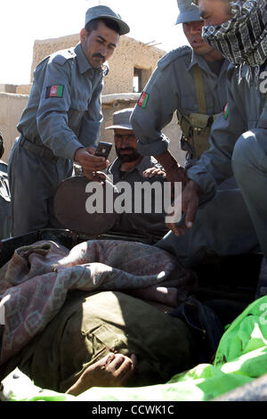 17. Mai 2010 - Provinz Herat, Afghanistan – afghanische Polizei schießen Fotos der Leiche eines vermuteten Taliban-Kämpfer getötet wurde, während der Kämpfe noch zwei US-Armee Fahrzeuge, die in der Provinz Herat, Afghanistan, auf Montag, 17. Mai 2010 deaktiviert. US-Armee Soldaten aus Alpha-Truppe, 4. Squ Stockfoto