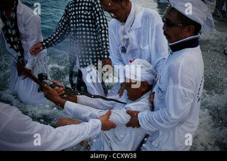 13. März 2010 - Denpasar, Bali, Indonesien - A Balinese hinduistischen Anhänger in Trance von stechenden seinen Körper mit traditionellen Dolch während Reinigungszeremonie genannt Melasti. Das Ritual wird geglaubt, um ihre Seelen und heiligen Zeremonien Ausrüstung reinigen durch Eintauchen in das Wasser des Meeres. Nyepi, Balinesen Stockfoto