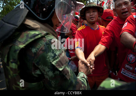 27. März 2010 - Bangkok, Thailand - Thai Soldat in anti-Kampfausrüstung Händeschütteln mit Anti-Regierungs-Demonstranten beim verlassen das Gelände des buddhistischen Tempels in Nähe der Regierungsgebäude. Anti-Regierungs-Demonstranten wurden jubeln und schreien Worte des Dankes an die Armee als Soldaten l Stockfoto