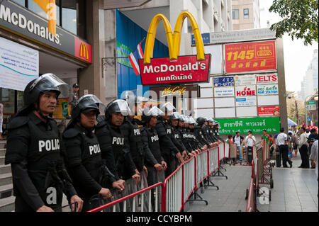 5. April 2010 Vergehen Silom Road, im Herzen des financial District von Bangkok - Bangkok, Thailand - Polizisten außerhalb eines McDonalds's bewacht das kommerzielle Zentrum als Anti-Regierungs-Demonstranten. Proteste gegen die Regierung organisiert von Vereinigten Front für Demokratie gegen Diktatur (UDD) Stockfoto