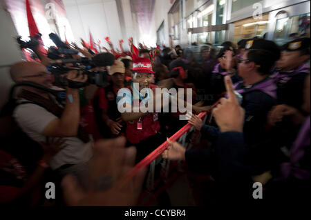 5. April 2010 - Bangkok, Thailand - Rothemden anschreien Polizei bei dem Versuch, die Barrikade zu entfernen. Red Shirts drangen in das Gebäude der Wahlkommission Büros verlangen die lange aufgeschobene Entscheidung über einen Fall, der zur Auflösung der Partei führen könnte. Die Regierung soug Stockfoto