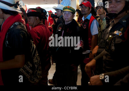 5. April 2010 - Bangkok, Thailand - Anti-Regierungs-Demonstranten stehen inmitten von Polizei und seine Kameraden im großen Saal der Regierung zu bauen, nachdem sie in das Gebäude, den Büros der Wahlkommission in der Regierung Komplex auf Chaeng Wattana Road in Bangkok, Thailand brach. Rotes Hemd Stockfoto