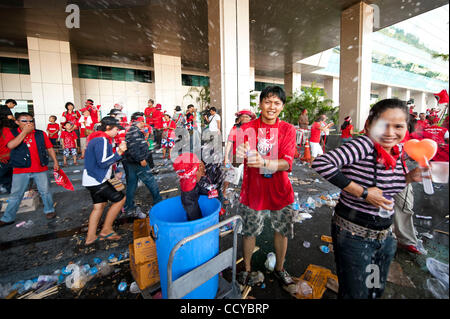 5. April 2010 verschoben - Bangkok, Thailand - Anti-Regierungs-Demonstranten Demonstranten gießen Wasser auf einander als die Demonstranten Weg von der Haupthalle der Regierung zu bauen, nachdem sie brach in das Gebäude Büros der Wahlkommission in der Regierung Komplex auf Chaeng Wattana Road Stockfoto