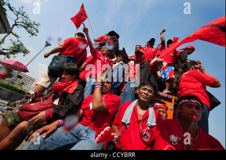 5. April 2010 - Bangkok, Thailand - Anti-Regierungs-Demonstranten schwenkten Fahnen, wie sie in Veranstaltungsort verschoben, um die Proteste gehen weiter, nachdem sie die Gebäude, in den Büros der Wahlkommission in der Regierung Komplex auf Chaeng Wattana Road in Bangkok, Thailand brach in. Rothemden fordern die Stockfoto