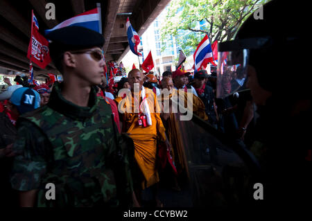 6. April 2010 - Bangkok, Thailand - buddhistischer Mönch starrt thailändische Soldaten während der massiven Kundgebung der Rothemden in Rajaprasong wohlhabenden Gegend von Zentrum von Bangkok am 6. April 2010. Es gibt zunehmende Anzahl von buddhistischen Mönchen in verschiedenen anti-Regierungs-Proteste. Thailändische Armee wurde auf Straßen eingesetzt. Stockfoto