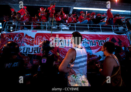 6. April 2010 - Bangkok, Thailand - A Tourist im Besitz einer Stadtkarte sieht der Konvoi von red Shirt Demonstranten paradieren die wohlhabenden Viertel von Bangkok. Als sich die Demonstrationen vierte Woche der anti-Regierungs-Demonstranten stürmen die Straßen von Bangkok sind die Ereignisse zunehmend von besucht. Stockfoto