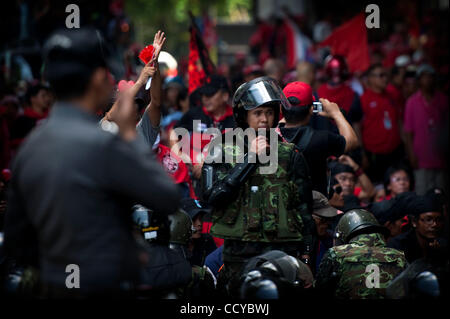 6. April 2010 - Bangkok, Thailand - Thai Soldat in anti-Kampfausrüstung blickt auf während es Kollegen waren umgeben von roten Hemd Unterstützer während die Rothemden off mit den Strafverfolgungsbehörden in Rajaprasong am 6. April 2010 in Bangkok Thailand Face. Thailändische Armee wurde auf den Straßen von Bangkok nach Hel eingesetzt. Stockfoto