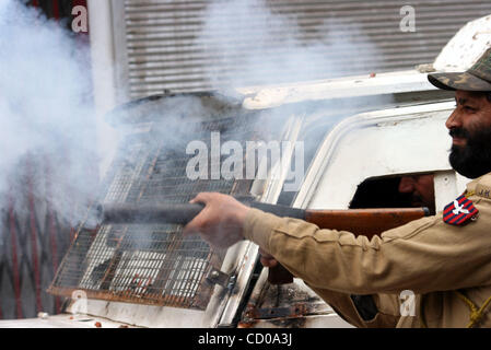 Ein indischer Polizist feuert eine Tränengas-Shell in Richtung Kaschmir muslimische Demonstranten während einer Protestaktion in Srinagar 11. April 2008. Polizei im indischen Teil Kaschmirs feuerte Tränengas am Freitag Hunderte von Demonstranten fordern eine Untersuchung fast tausend unmarkierte Gräber in Kaschmir von entdeckt zu zerstreuen Stockfoto