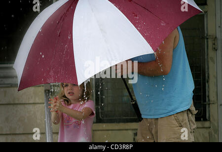 3. Juni 2008 spielt - Mishawaka, Indiana, USA - Leah Holcomb, 6, im Regen auf der Veranda ihres Hauses in Mishawaka, Indiana, als ihr Vater, David, 43, etwas Schutz mit einem Regenschirm bietet.  (Jim Z. Rider/South Bend Tribune, ZUMA Press) Stockfoto