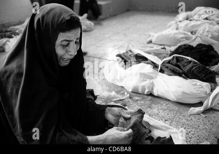 21. Mai 2003 - Al-Musayab, Irak - schreit eine Frau in Frustration, Suche nach ihrem vermissten Angehörigen unter den Knochen in die Wanten, die das Gymnasium des lokalen Sportzentrums in Al-Musayab, Irak zu füllen. Das Zentrum ist heute die Heimat von einer irakischen Menschenrechtsorganisation, die die Exhumat beaufsichtigt Stockfoto