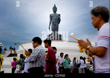 26. Juli 2010 - Nakhon Pathom, Thailand - Thais halten Kerzen in einem Outdoor-Prozession um eine 15,87 m hohe Buddha-Statue buddhistischen Fastenzeit tagsüber an Phutthamonthon. Die Statue gilt als der höchste frei stehende Buddha-Statue der Welt. Phutthamonthon ist ein buddhistischer park Stockfoto