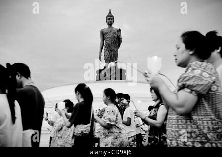 26. Juli 2010 - Nakhon Pathom, Thailand - Thais halten Kerzen in einem Outdoor-Prozession um eine 15,87 m hohe Buddha-Statue buddhistischen Fastenzeit tagsüber an Phutthamonthon. Die Statue gilt als der höchste frei stehende Buddha-Statue der Welt. Phutthamonthon ist ein buddhistischer park Stockfoto