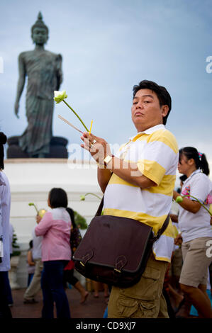 26. Juli 2010 - Nakhon Pathom, Thailand - Thais halten Kerzen in einem Outdoor-Prozession um eine 15,87 m hohe Buddha-Statue buddhistischen Fastenzeit tagsüber an Phutthamonthon. Die Statue gilt als der höchste frei stehende Buddha-Statue der Welt. Phutthamonthon ist ein buddhistischer park Stockfoto