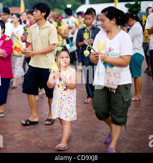 26. Juli 2010 - Nakhon Pathom, Thailand - Thais halten Kerzen in einem Outdoor-Prozession um eine 15,87 m hohe Buddha-Statue buddhistischen Fastenzeit tagsüber an Phutthamonthon. Die Statue gilt als der höchste frei stehende Buddha-Statue der Welt. Phutthamonthon ist ein buddhistischer park Stockfoto