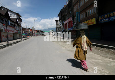 Eine Kashmiri Fisher Frau geht eine Desterd Straße während der Ausgangssperre in Srinagar, der Sommerhauptstadt des indischen Teil Kaschmirs am 11. August 2010. Viele der indischen Teil Kaschmirs Straßen liegen einsame abgesehen von streunenden Hunden. Polizei, tötete Dutzende von Demonstranten trotzt Indiens Bemühungen, ein Separatist Aufstand zu unterdrücken, Stockfoto