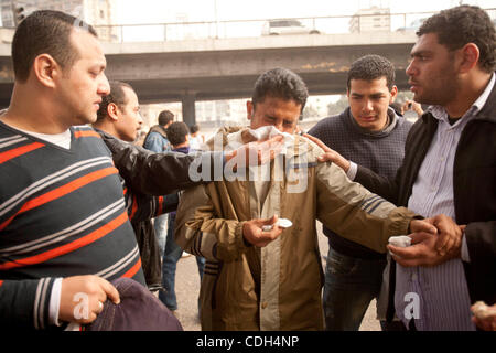 28. Januar 2011 - Kairo, Ägypten - Fellow Ägyptische Demonstranten helfen einander und demonstriert. Ägypter unter der 6. Oktober-Brücke an der Corniche auf dem Nil in der Innenstadt von Kairo, in einer konzertierten Aktion auf vergangenen Polizeigewalt aufmerksam demonstriert Armut und die steigenden Kosten des Lebens in Stockfoto