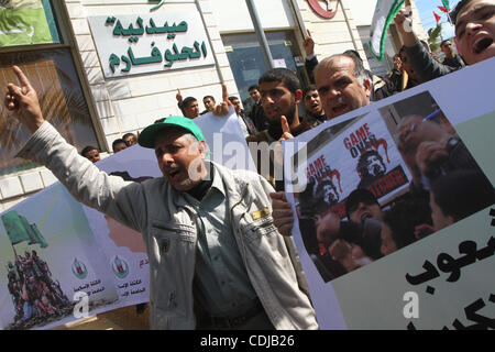 22. Februar 2011 - Gaza-Stadt, Gaza-Streifen - Palästinenser halten Plakate hoch während einer Protestaktion gegen den libyschen Führer in Gaza-Stadt. Der Gaza Hamas Herrscher gehäuft Verurteilung über die Massaker von Anti-Regierungs-Demonstranten in Libyen durch das Regime des kampfbereiten Herrschers begangen. (Kredit-Bild: © Ashraf Amra Stockfoto