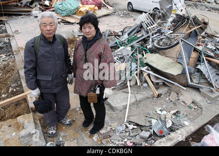 15. März 2011 stehen - Miyako, Japan - HIROSHI SAWAGUCHI (L) und seine Frau JUNKO SAWAGUCHI (R) auf dem Land, wo ihr Haus vor dem Erdbeben in Miyako, Iwate, Japan befand. Sie fanden ihr Haus etwa 15 Meter entfernt von der Herkunft, die durch den Tsunami verursacht durch die Magnitude 9 getragen wurde Stockfoto