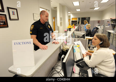 15. März 2011 - spricht Lawrenceville, GEORGIA, USA - Sergeant Greg Kapelle (L) mit dem Gwinnett County Sheriff Office Zivilgericht Division, mit Schreiber Nancy Hobson an der county Courthouse in Lawrenceville, Georgia USA am 25. Februar 2011. Nach Kapelle, seine Division hat einen Rückstand von mindestens f Stockfoto