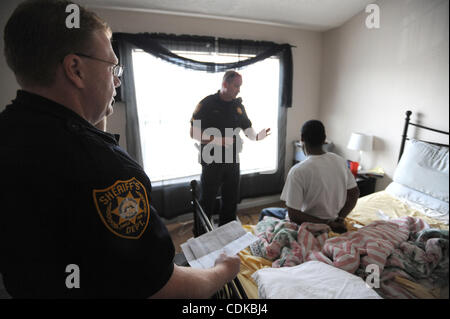 Sprechen Sie 15. März 2011 - Norcross, GEORGIA, USA - Sgt. Greg Chapel (C) und stellvertretender T. Wigenton (L) mit dem Gwinnett County Sheriff Office Zivilgericht Division, mit ihren Wohnsitz Maurice Adams nach seiner Verhaftung angeblich mit einem herausragenden Haftbefehl und Besitz von Marihuana, während seiner Tätigkeit eine evict Stockfoto