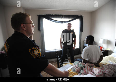 Sprechen Sie 15. März 2011 - Norcross, GEORGIA, USA - Sgt. Greg Chapel (C) und stellvertretender T. Wigenton (L) mit dem Gwinnett County Sheriff Office Zivilgericht Division, mit ihren Wohnsitz Maurice Adams nach seiner Verhaftung angeblich mit einem herausragenden Haftbefehl und Besitz von Marihuana, während seiner Tätigkeit eine evict Stockfoto